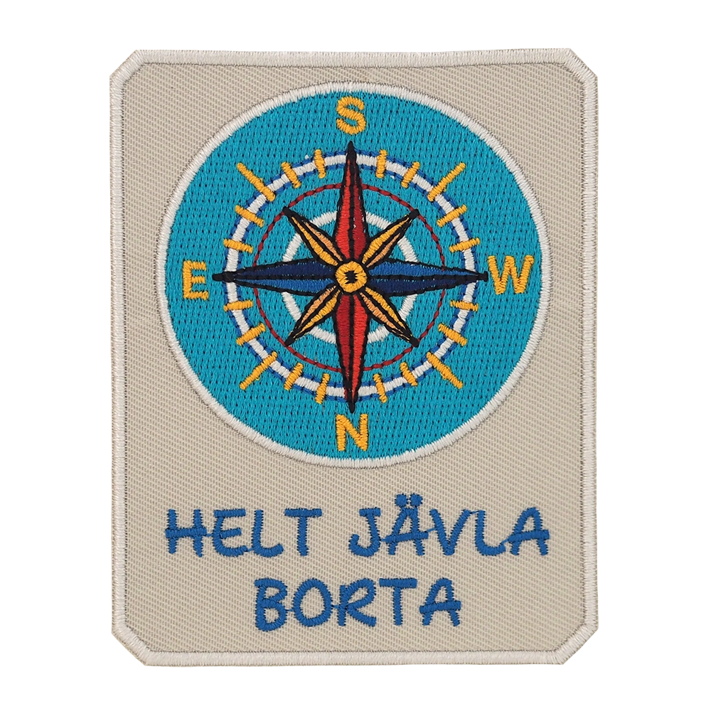 Brodeerattu haalarimerkki, kompassi, teksti: Helt jävla borta.