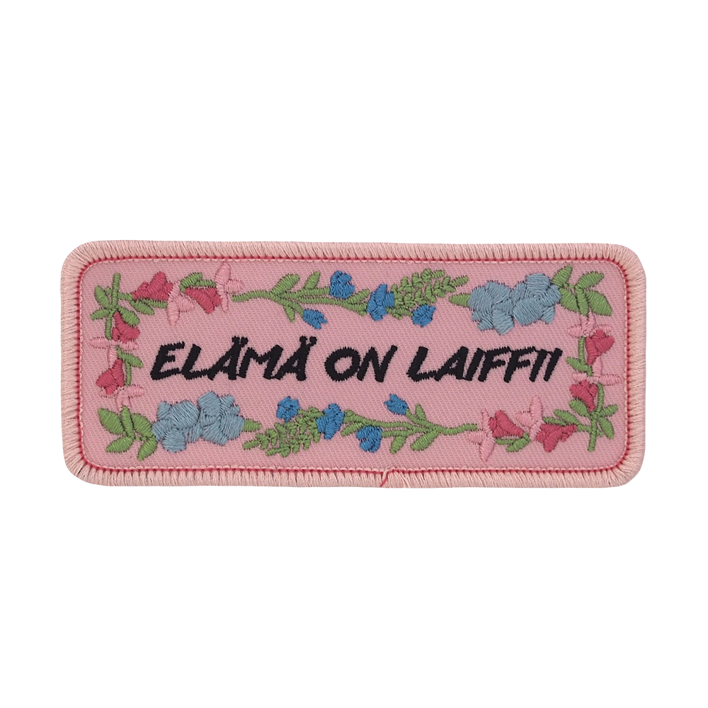 Brodeerattu haalarimerkki, kukkia, teksti: Elämä on laiffii.