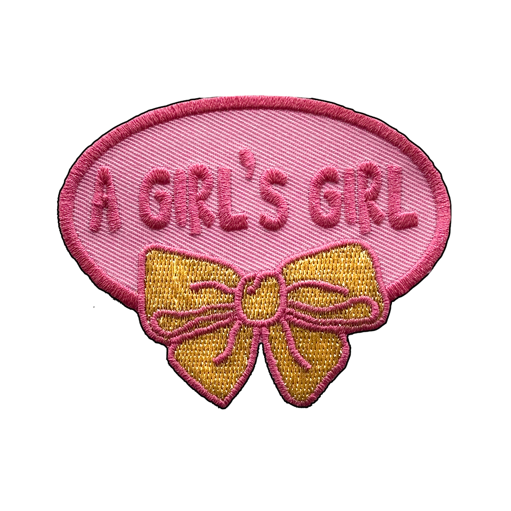 Brodeerattu kangasmerkki, rusetti, teksti: A girl's girl.