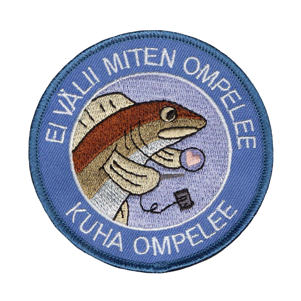 Brodeerattu kangasmerkki, kala, teksti: Ei välii miten ompelee, kuha ompelee.
