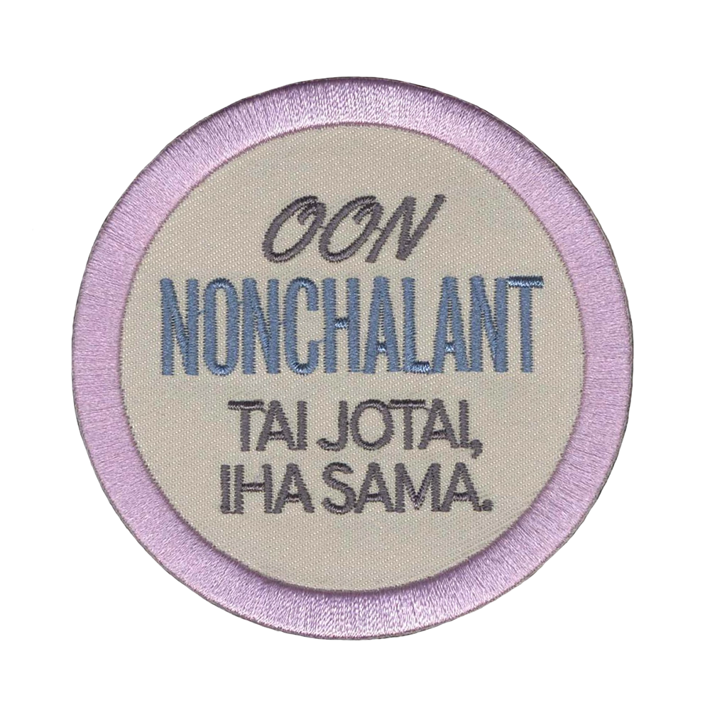 Brodeerattu kangasmerkki, teksti: Ooon nonchalant tai jotai, iha sama.