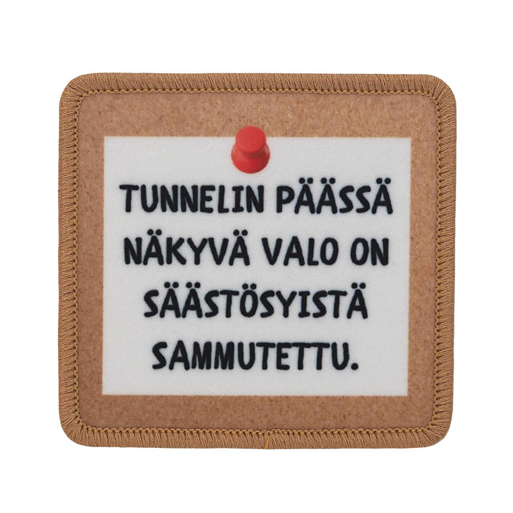 Painettu kangasmerkki, teksti: Tunnelin päässä näkyvä valo on säästösyistä sammutettu.