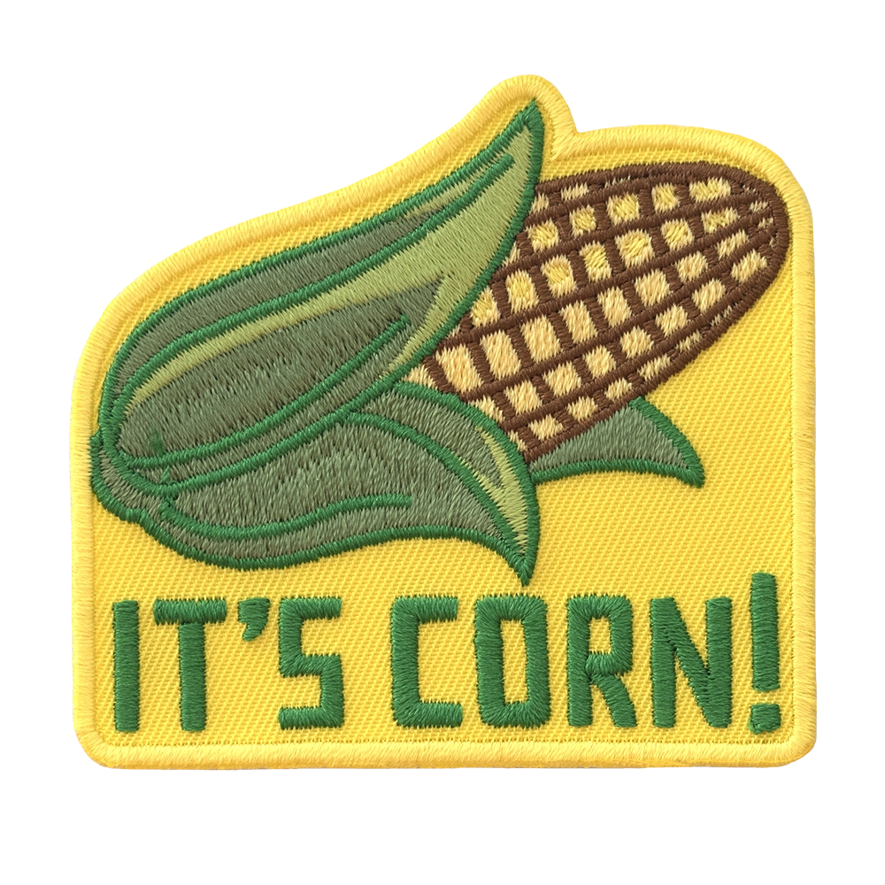 Brodeerattu keltainen maissi-aiheinen haalarimerkki, teksti: It's corn. 