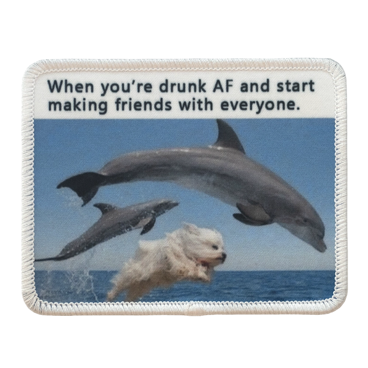 Painettu haalarimerkki, delfiinejä ja koira, teksti: When you're drunk AF and start making friends with everyone.