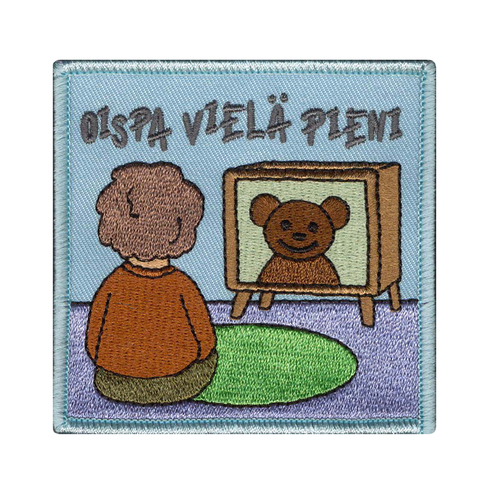 Brodeerattu kangasmerkki, lapsi katsoo televisiota.