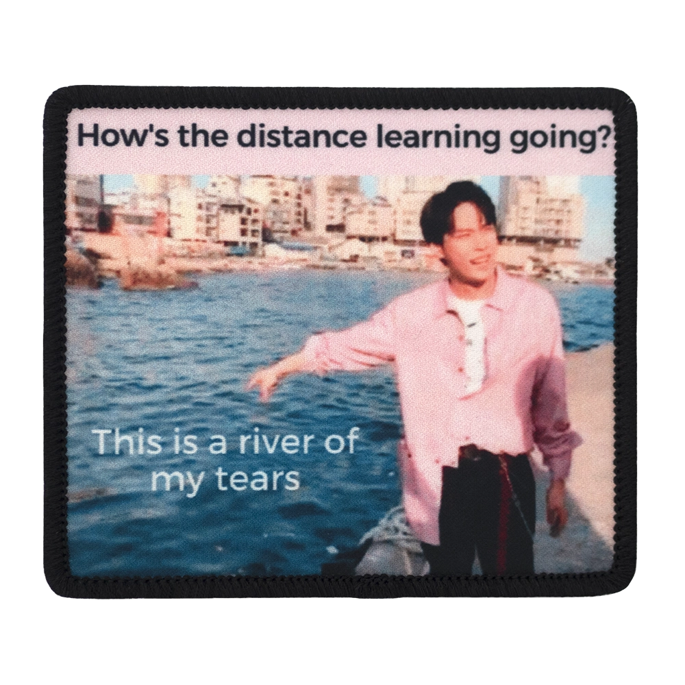 Painettu haalarimerkki, hahmo osoittaa jokea, teksti: How's the distance learning going?